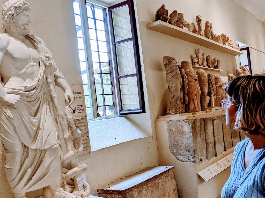 a young woman in a museum of Greek artifacts and statues