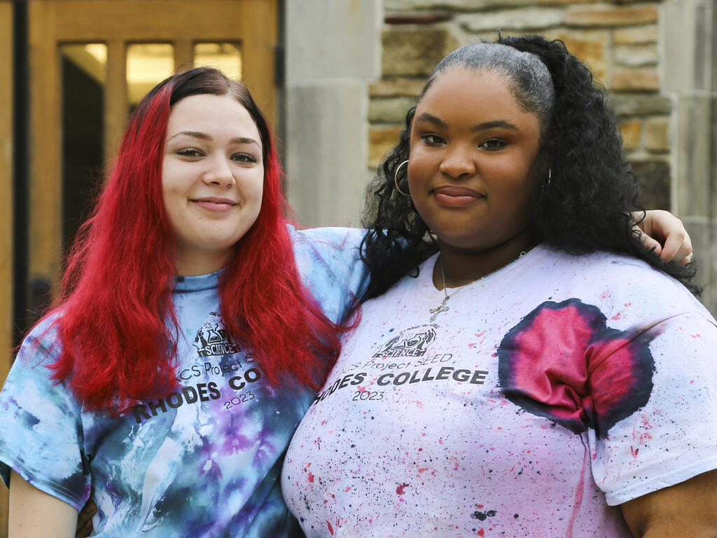 two female high school students smile at the camera