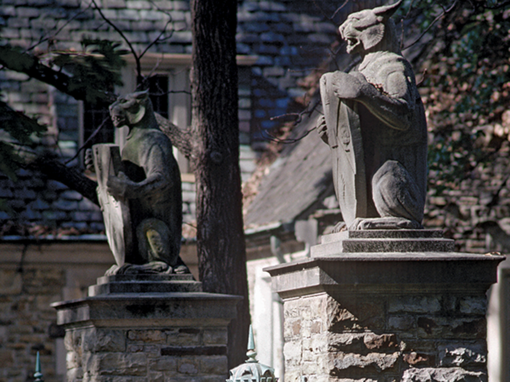 two lynx gargoyles amongst gothic architecture and trees