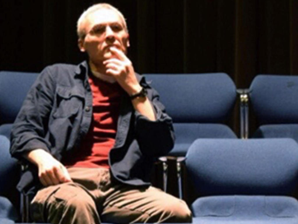 a man sitting pensively in theatre seats