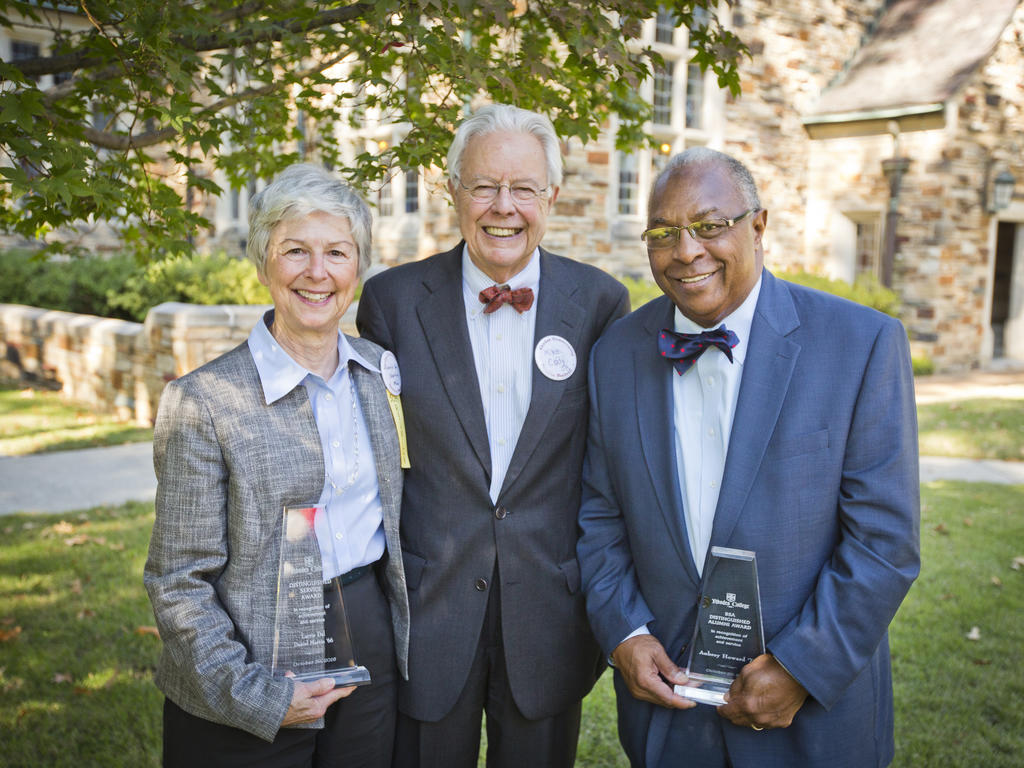 three older Rhodes alumni holding their awards: one woman, one white man, and one African American man