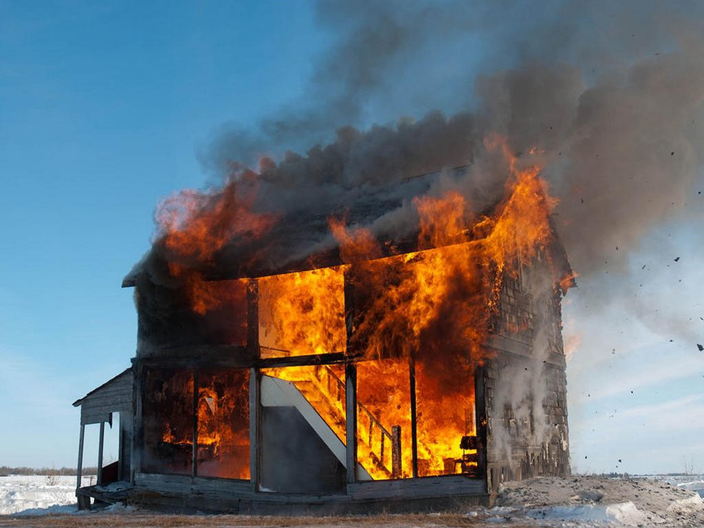 a house on fire in the middle of nowhere